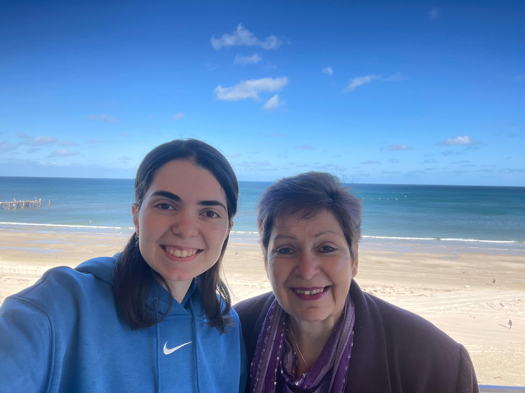 Older lady and her adult daughter with sea in the background